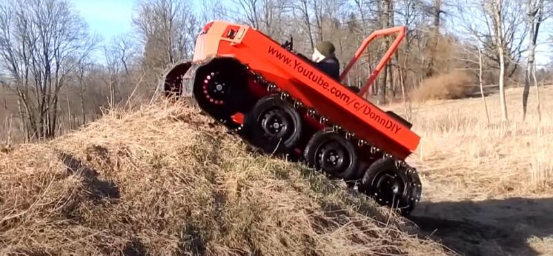 A craftsman assembles a tracked all-terrain vehicle from scrap metal